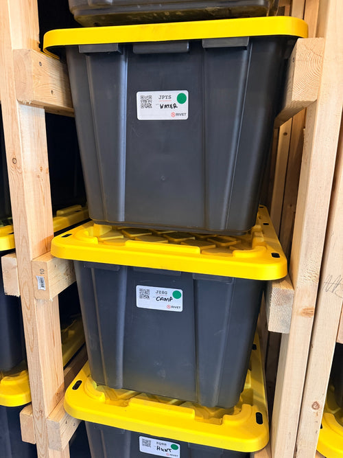 RIVET Starter labels on organized garage totes with handwritten water, camp and hunt notes